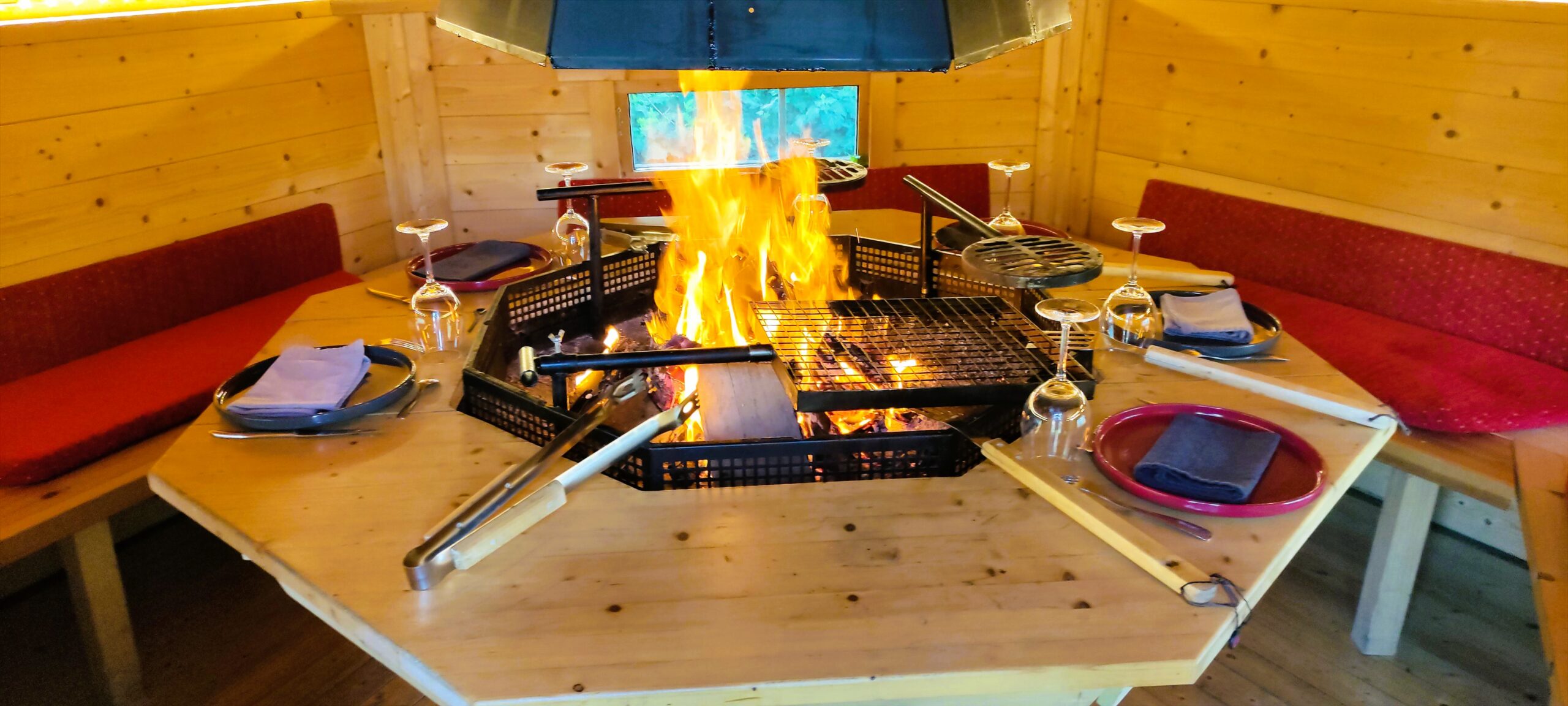 Intérieur du Kota Grill avec le feu de bois et la table dressée